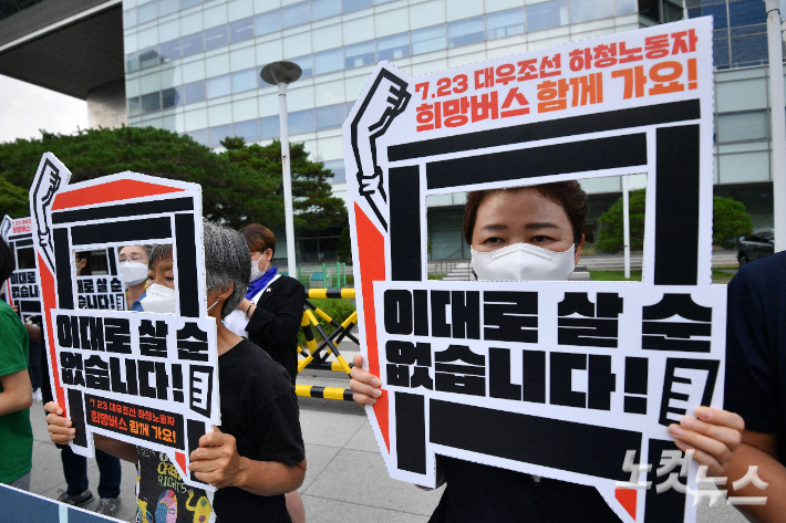 19일 서울 여의도 산업은행 앞에서 열린 7.23 대우조선 하청노동자 희망버스 세부계획 발표 기자회견에서 참석자들이 피켓을 들고 있다. 류영주 기자