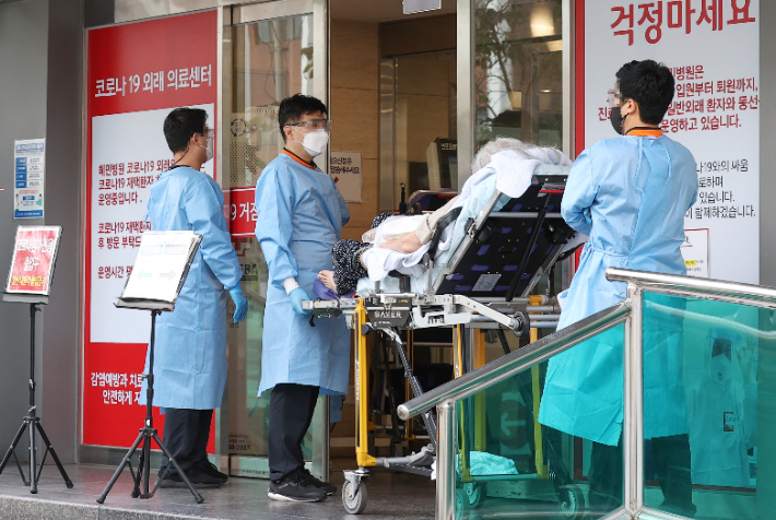 서울 광진구 혜민병원에서 구급대원들이 코로나19 환자를 옮기고 있다. 연합뉴스