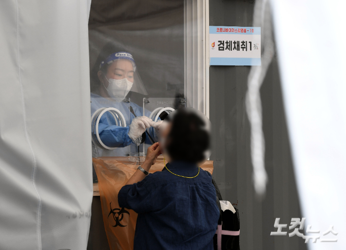 3일 오후 서울역광장에 마련된 코로나 19 임시선별검사소에서 의료진이 검체채취를 하고 있다.   황진환 기자