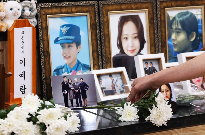공군 성폭력 피해자 고(故) 이예람 중사의 추모의 날에 한 추모객이 고인의 사진 앞에 국화꽃을 놓고 있는 모습. 연합뉴스