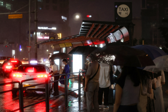 폭우가 내린 8일 오후 시민들이 서울 용산구 용산역 인근 택시승차장에서 줄을 서 택시에 타고 있다. 연합뉴스