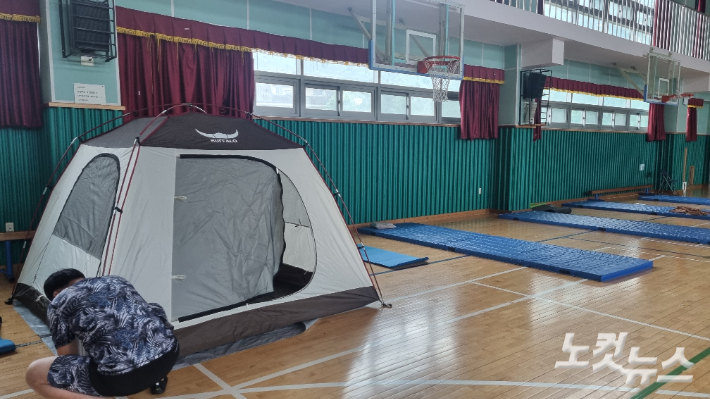 9일 오전 서울 동작구 문창초등학교 체육관에 마련된 임시대피소에 한 이재민이 텐트를 설치하고 있다. 백담 기자