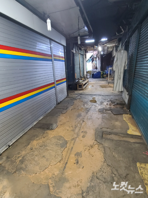 인천 동구 송현시장 내 상가건물 내부 모습. 전날부터 내린 폭우로 가게 대부분이 문을 닫았고 건물 바닥에는 빗물과 함께 유입된 진흙이 쌓여 있다. 주영민 기자