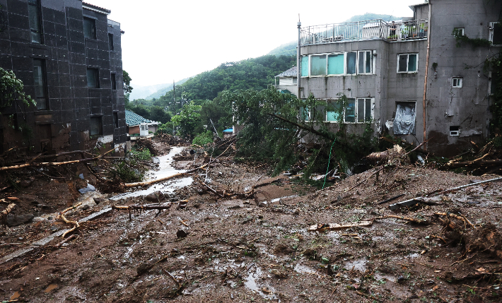 9일 오후 전날부터 중부지방에 내린 많은 비로 산사태가 발생한 경기도 광주시 한 마을이 토사와 나무로 뒤덮여 있다. 연합뉴스
