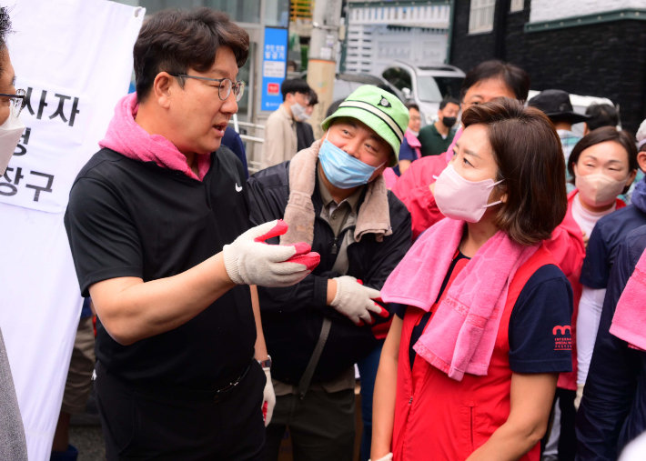 국민의힘 권성동 원내대표와 나경원 전 의원이 11일 서울 동작구 사당2동 주민센터 앞에서 수해지역 자원봉사를 나서며 대화를 하고 있다. 국회사진취재단