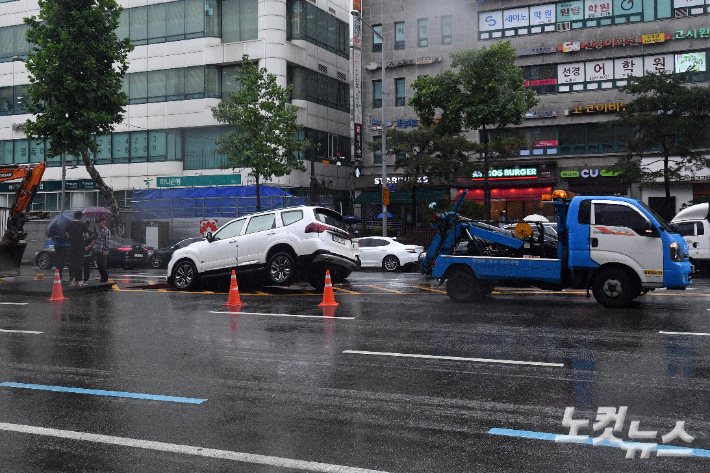 지난 9일 서울 대치역 인근 도로에 지난밤 폭우로 침수된 차량에 대한 견인 작업이 이뤄지고 있다. 박종민 기자