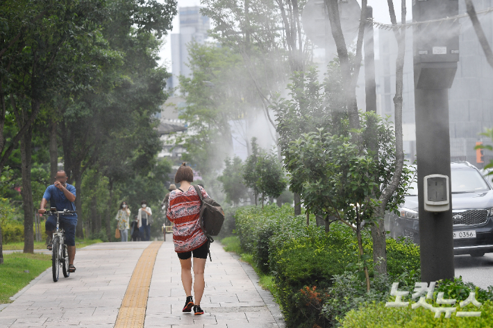 서울 시내의 한 거리에서 시민들이 '쿨링포그' 길을 걸으며 더위를 식히고 있다. 류영주 기자