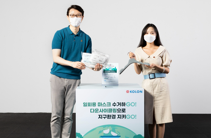 코오롱그룹 임직원들이 사용 후 버려진 마스크로 만든 재활용 옷걸이를 마스크 수거함 앞에서 소개하고 있다. 코오롱그룹 제공