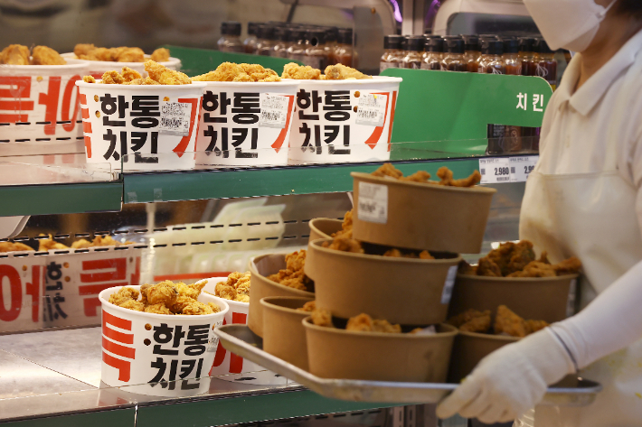 저렴한 대형마트 치킨이 인기를 끌고 있는 10일 서울 시내 한 대형마트에서 직원이 치킨을 진열하고 있다. 홈플러스와 이마트에 이어 롯데마트에서도 지난 11일 부터 한통치킨 가격을 44% 할인된 가격에 판매한다. 연합뉴스