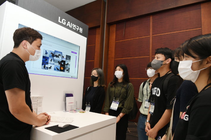18일 서울 코엑스에서 열린 '2022 인공지능대학원 심포지엄' LG AI연구원 부스 담당자가 초거대 멀티모달 AI 'EXAONE(엑사원)' 기술을 설명하고 있다. LG 제공