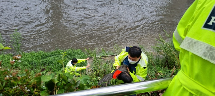 20일 부산 온천천 산책로에서 갑자기 불어난 물에 고립됐던 시민이 경찰에 구조되는 모습. 부산경찰청 제공
