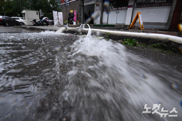 지난 9일 서울 서초구 한 아파트 상가 지하에 빗물 배수 작업이 이뤄지고 있다. 박종민 기자