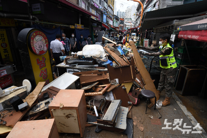 서울 동작구 남성사계시장에서 침수로 피해를 입은 상인들과 군인들이 복구 작업을 하는 모습. 황진환 기자