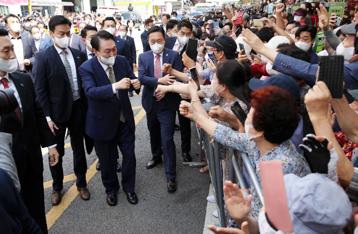 윤석열 대통령이 26일 오후 대구 중구 서문시장을 방문, 시민들과 주먹 인사를 하고 있다. 연합뉴스