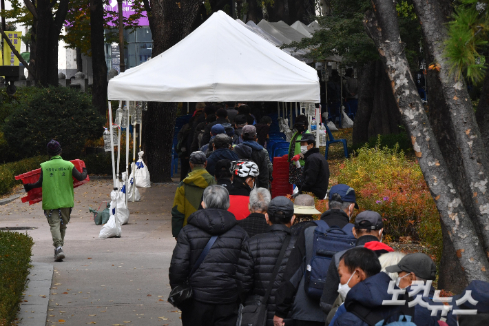 서울 종로구 탑골공원에서 어르신들이 원각사 무료급식소에서 제공하는 도시락을 받기 위해 줄을 서 있다. 박종민 기자