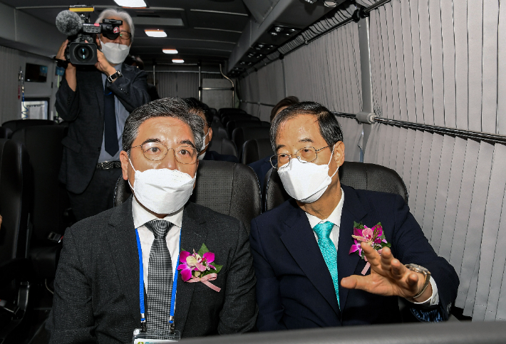 한덕수 국무총리(오른쪽)가 31일 경기도 고양시 킨텍스에서 열린 'H2 MEET 2022' 전시회 현대차그룹관에 전시된 현대차 수소전기버스 경찰버스에 탑승해 장재훈 현대차 사장(왼쪽)으로부터 설명을 듣고 있다. 현대자동차 제공