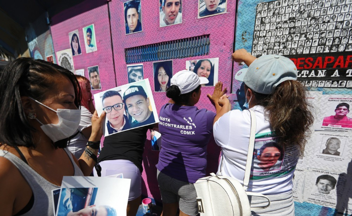 벽에 실종 자녀와 친지 사진을 붙이는 멕시코 실종자 가족. 연합뉴스