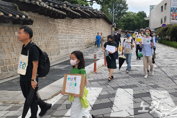 기도회를 가진 뒤 '지구별 순례길' 걷기 운동을 진행하고 있는 기도회 참가자들. 손에는 적극적인 기후위기 대응을 촉구하는 손팻말을 들었다.