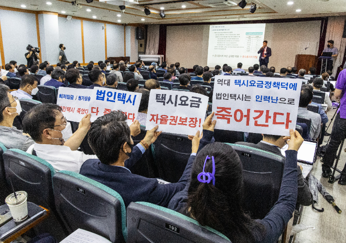  5일 오후 서울 관악구 교통문화교육원 대강당에서 열린 '서울시 택시요금 정책 개선 공청회'에서 택시 업계 관계자들이 법인 택시요금 자율권 보장 등이 담긴 피켓을 들고 침묵시위를 벌이고 있다. 연합뉴스