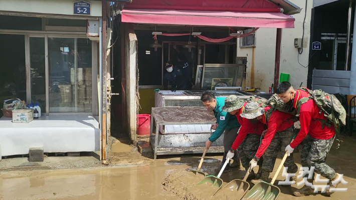 8일 땡볕 아래서 해병대원들이 가게 앞 진흙을 쓸어내 진입로를 확보하는 작업이 한창이다. 박희영 수습기자
