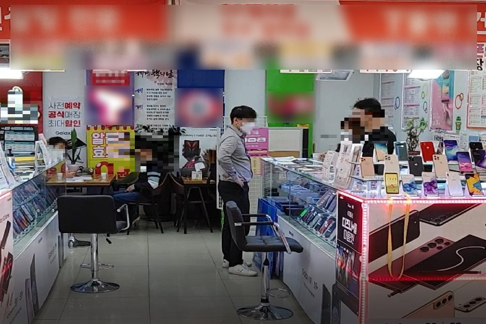 경찰이 지난 7월 대전의 한 휴대전화 대리점에서 판매 조직원을 검거하고 있다. 부산경찰청 제공