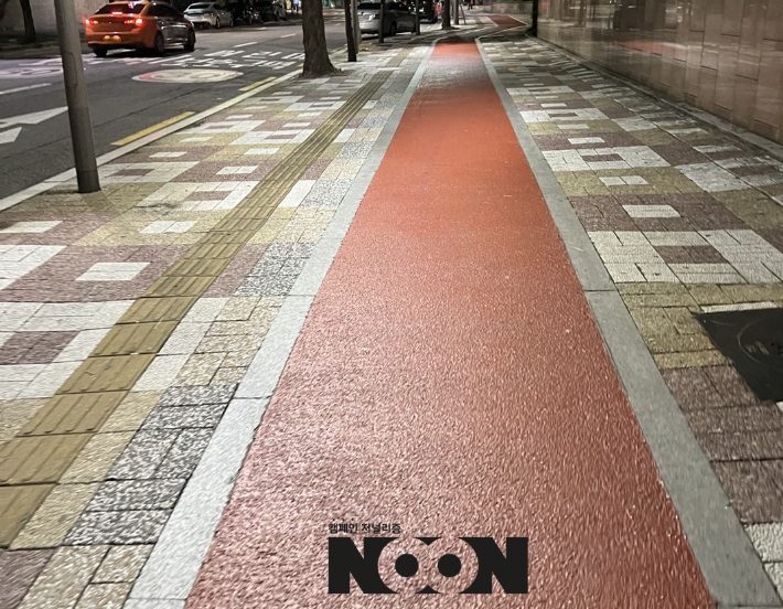 서울시 여의도 지역의 한 보도 위에 설치된 자전거 도로의 모습.  보도 중간에 설치된 자전거 도로와 인도, 인도 위 시각장애인을 위한 점자 블록이 어색함을 준다. 공공소통연구소 제공