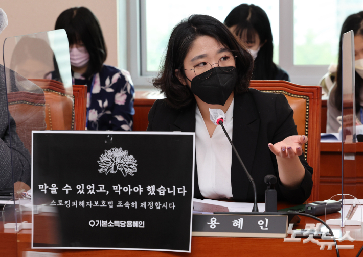 기본소득당 용혜인 의원이 16일 오전 서울 여의도 국회에서 열린 여성가족위원회 전체회의에서 스토킹피해자보호법 제정 촉구 문구를 의석에 붙이고 질의하고 있다. 윤창원 기자