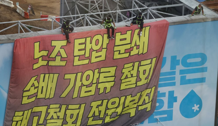 하이트진로에서 고공농성을 펼치고 있는 화물노동자들이 지난 8월 18일 서울 강남구 하이트진로 본사 앞에서 열린 고공농성투쟁 승리 결의대회를 지켜보고 있다. 연합뉴스
