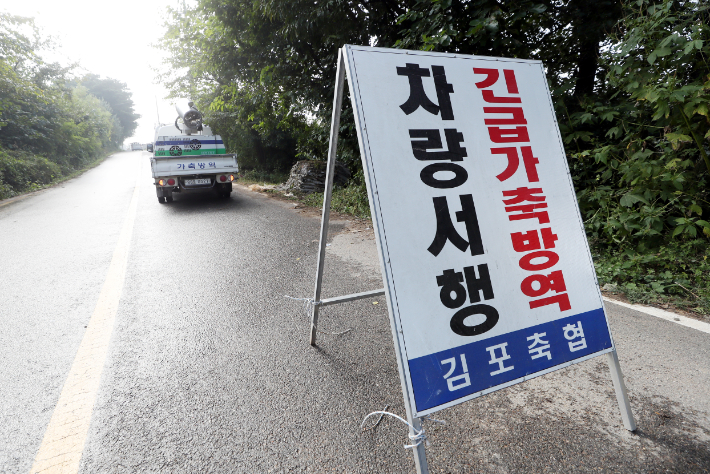 경기도 김포·파주·평택시 등 3개 농가에 아프리카돼지열병(ASF)이 발생해 방역당국에 비상이 걸린 가운데 29일 오전 아프리카돼지열병 확진 판정을 받은 경기도 김포시 모 양돈농가 진입로에 긴급가축방역 안내판이 설치돼 있다. 연합뉴스