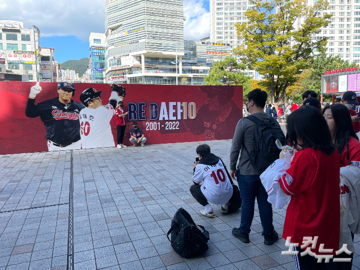 이대호의 은퇴를 기념하는 대형 사진 앞에서 기념 촬영을 하고 있는 야구 팬들. 부산=김조휘 기자