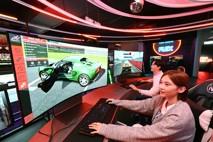 모델들이 시청환경에 맞춰 자유롭게 화면을 구부렸다 펼 수 있는 LG 올레드 플렉스로 게임을 즐기고 있는 모습. LG전자 제공