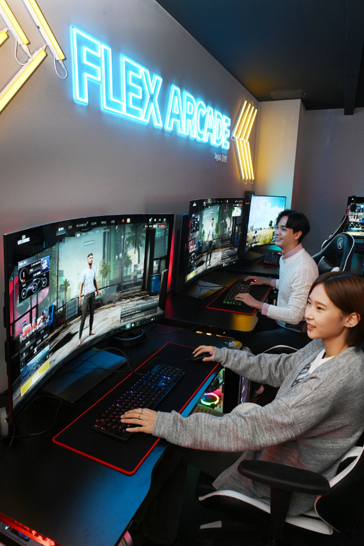 모델들이 시청환경에 맞춰 자유롭게 화면을 구부렸다 펼 수 있는 LG 올레드 플렉스로 게임을 즐기고 있는 모습. LG전자 제공