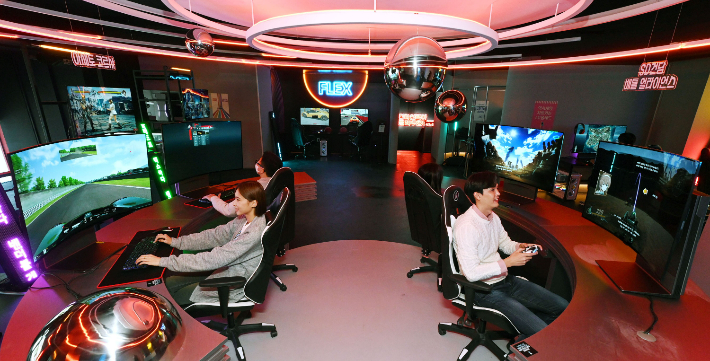 모델들이 시청환경에 맞춰 자유롭게 화면을 구부렸다 펼 수 있는 LG 올레드 플렉스로 게임을 즐기고 있는 모습. LG전자 제공