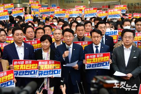 더불어민주당 조정식 사무총장이 의원들과 19일 서울 여의도 중앙당사 앞에서 검찰의 압수수색 시도를 규탄하는 입장을 밝히고 있다.