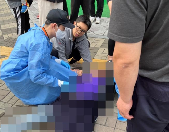 심폐소생술로 행인을 구한 간호사 김도연 씨가 출동한 구급대원에게 환자를 인계하고 있다. 제보자 제공