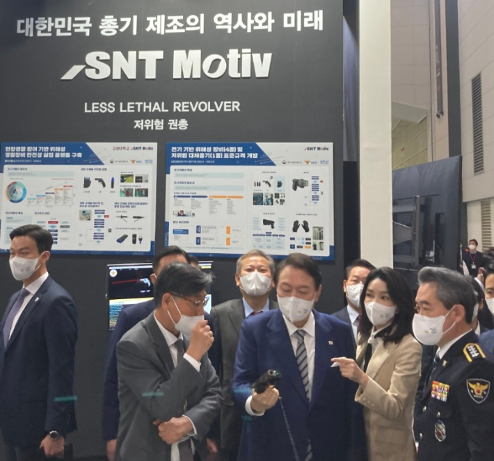 윤석열 대통령과 김건희 여사가 20일 경찰의 날을 맞아 인천 송도컨벤시아에서 열리고 있는 국제치안산업대전에 방문해 글로벌 소구경 화기 제조업체인 SNT모티브 부스를 찾아 최광영 대표이사로부터 STRV9 저위험 권총에 대한 설명을 듣고 있다. SNT모티브 제공