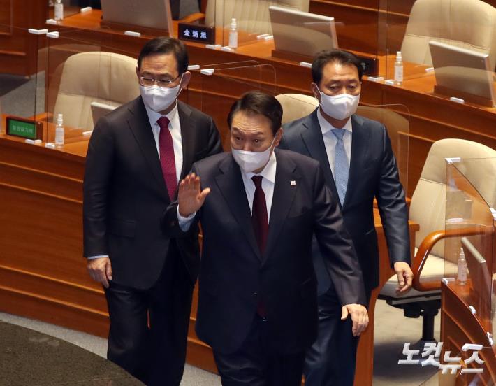 윤석열 대통령이 25일 서울 여의도 국회 본회의장에서 2023년 예산안 시정연설을 마치고 국무위원들을 향해 손 인사를 하고 있다.