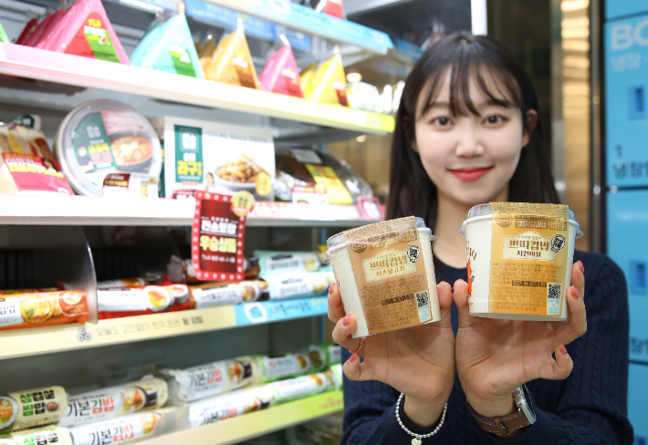모델이 GS25가 출시한 쁘띠 컵밥 2종을 들고 포즈를 취하고 있다. 치즈불고기, 치킨마요를 들고 포즈를 취하고 있다. GS25 제공