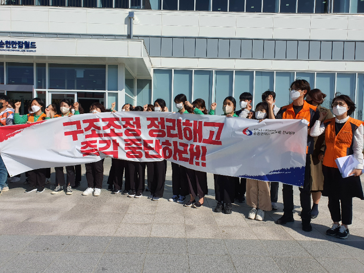 순천만잡월드 노동자들이 구조조정 정리해고 즉각 중단 현수막을 들고 있다. 고영호 기자
