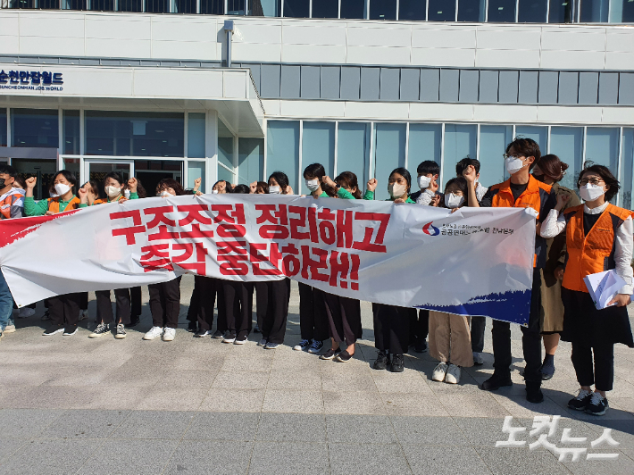 순천만잡월드 노동자들이 구조조정 정리해고 즉각 중단 현수막을 들고 있다. 고영호 기자