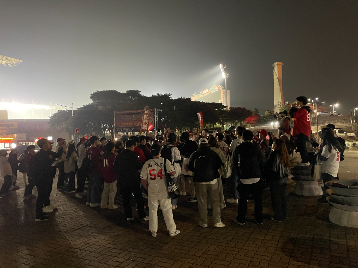 9일 2022 신한은행 SOL KBO 한국시리즈 6차전이 열린 인천 SSG랜더스필드. SSG의 우승이 확정된 뒤 경기장 앞에 모인 팬들이 응원가를 부르며 우승을 자축하고 있다. 인천=김조휘 기자