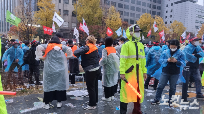 Members of the Korean Confederation of Trade Unions who are in charge of keeping order wear orange vests.  Reporter Baekdam