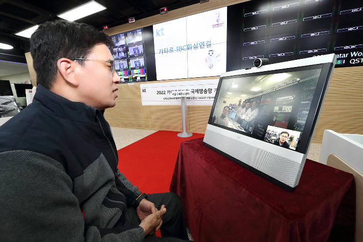 KT 강북강원광역본부장 안치용 전무(왼쪽)가 KT 강북강원네트워크운용본부장 이상일 상무(모니터 내부 왼쪽)와의 화상 통화를 통해 카타르 국제방송센터(IBC) 현지 상황을 점검하고 있다. KT 제공   