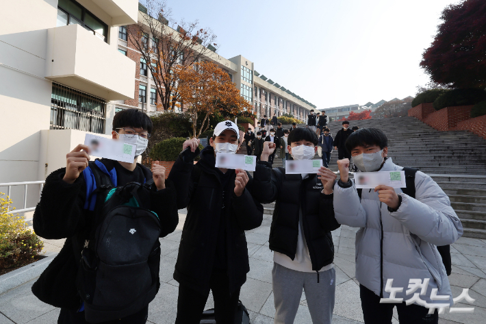 2023학년도 대학수학능력시험을 하루 앞둔 16일 오전 서울 종로구 동성고등학교에서 수험생들이 수험표를 들어보이고 있다. 사진공동취재단