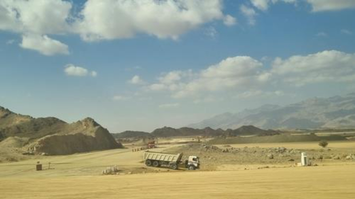 사우디아라비아 북서부 네옴시티로 향하는 도로변을 덤프트럭이 오가고 있다. 연합뉴스
