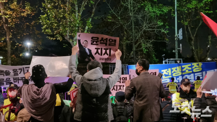 19일 오후 8시쯤 촛불전환행동 측과 신자유연대 측이 서로를 향해 구호를 외치고 있다. 양형욱 기자