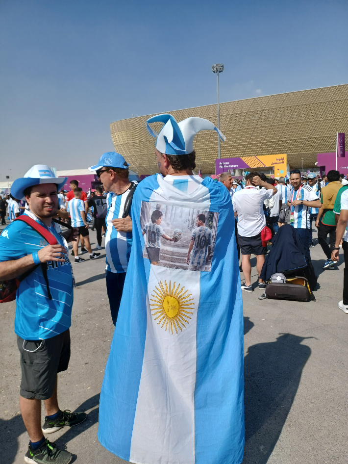 메시와 마라도나의 페이팅이 된 국기를 두르고 있는 아르헨티나 팬. 