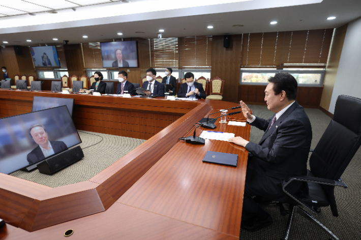 윤석열 대통령이 23일 서울 용산 대통령실 청사에서 화상으로 테슬라 최고경영자(CEO) 일론 머스크를 접견한 뒤 작별인사를 하는 모습. 연합뉴스