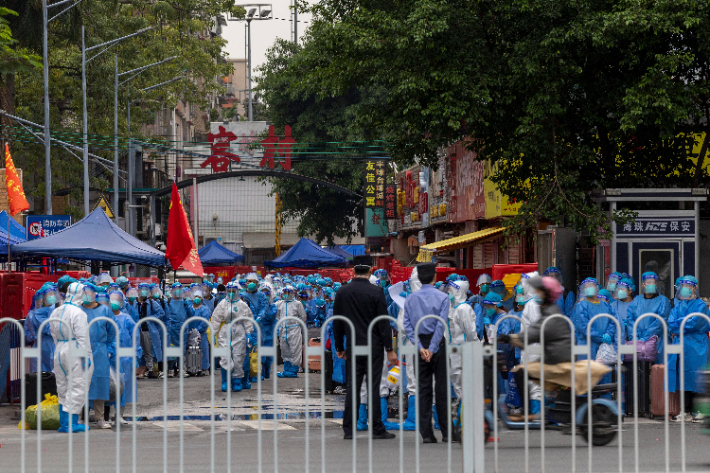 중국 광둥성 광저우의 주민들이 파란 방역복을 입고 코로나19 방역 센터로 이송될 준비를 하고 있다. 연합뉴스