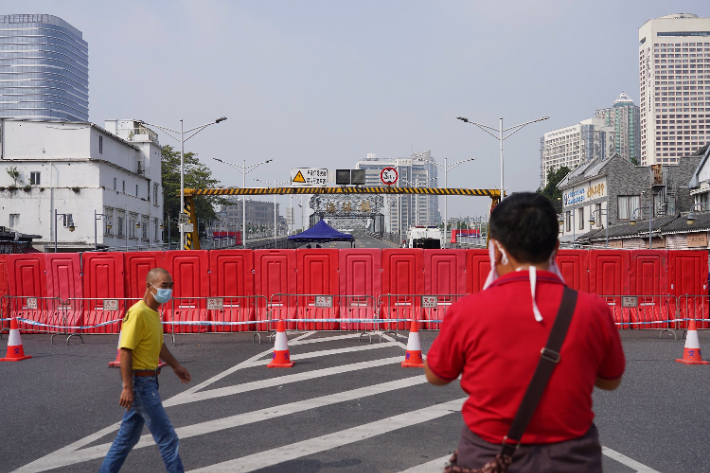 남부 제조업 중심지 광저우와 서부 메가시티 충칭에서 500만 명 이상의 사람들이 봉쇄되었다. 11월 11일 마스크를 쓴 주민이 당국이 세운 봉쇄 벽을 보고 있다.연합뉴스